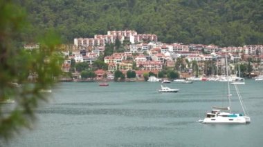 Türkiye 'de Fethiye sahili manzarası. Fethiye, Türk Rivierası 'nda popüler bir turizm beldesi. Yatlar ve yelkenliler, yaz mevsimi Marina 'sında turkuaz sularda demirlemişti. Liman ve yat manzaralı Fethiye Mugla