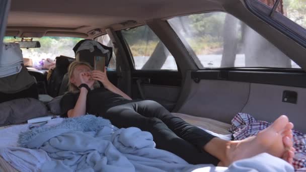 Молода Жінка Лежить Багажнику Машини Або Фургона Дивлячись Смартфон Читаючи — стокове відео