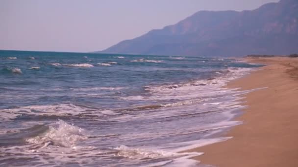 金碧辉煌的沙滩 背景清澈的海水和雄伟的高山 营造出令人叹为观止的自然景观 阳光灿烂的日子和波浪 复制空间 — 图库视频影像