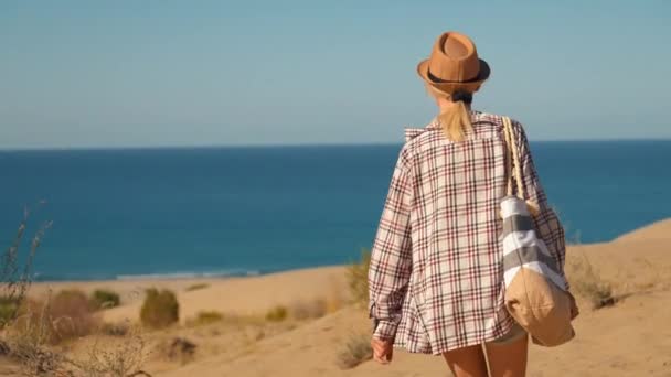Красивая Молодая Женщина Шляпе Пляжной Рубашке Идет Просторному Песчаному Пляжу — стоковое видео