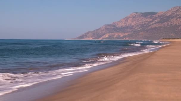 Vista Playa Arena Dorada Con Agua Mar Clara Majestuosas Montañas — Vídeo de stock