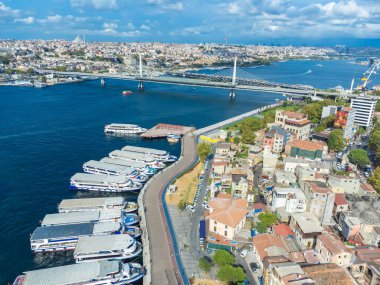 Güneşli bir günde, İstanbul, Türkiye 'de Golden Horn Köprüsü veya Halich Metro Köprüsü' nün arka planında demirli yolcu feribotlarının insansız hava aracı görüntüsü