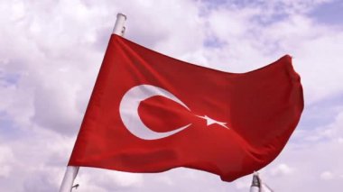 Türk bayrağı. Yakın plan. Bulutlu mavi gökyüzü ve arka planda İstanbul şehri. Türkiye 'nin ulusal bayrağı ağır çekimde sallanıyor.
