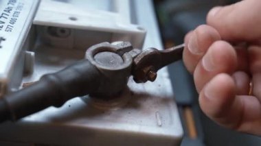 Uzun süre park etmeden önce arabanın aküsünü kesiyorum. Araç aküsünün bağlantısını kesiyor. Yeni aküyü değiştirdikten sonra araba aküsünü elinde tutan tamirci. Araba bakımı