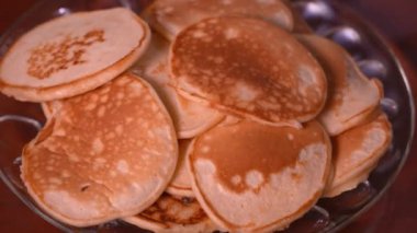 Tahta masaya, tabağa spatula istifleyen bir kadın eli. Bir sürü krep yığılmış. Çıtır çıtır krep. Kahvaltı ve karnaval için gözleme..