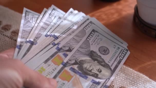 将100美元钞票放在木制桌子上的特写镜头 上面闪烁着美国的浅色现金 支付财政款项 利润概念 闭门造车100美元钞票 — 图库视频影像