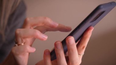 Manikürlü kadın ellerine yakın çekim, akıllı telefon kullanarak iş e-postalarını kontrol etmek ya da evde SMS mesajı göndermek, çevrimiçi iletişim kavramı. Blog, makale ya da yazı okuyor. Kamera.