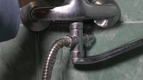 男士们手牵着破损 漏水水龙头软管在浴室里的特写镜头 管道问题的概念和水龙头修理的需要 管道工 — 图库视频影像