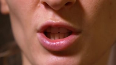 Vox pop tarzı hareket eden dudaklarla kameraya konuşan kadın ağzının yakın çekimi monolog yaparken dişleriyle konuşan kadın konuşmacının alt yüzü.