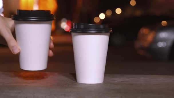 Şehir Işıklarının Bulanık Arka Planında Tek Kullanımlık Iki Beyaz Bardak — Stok video