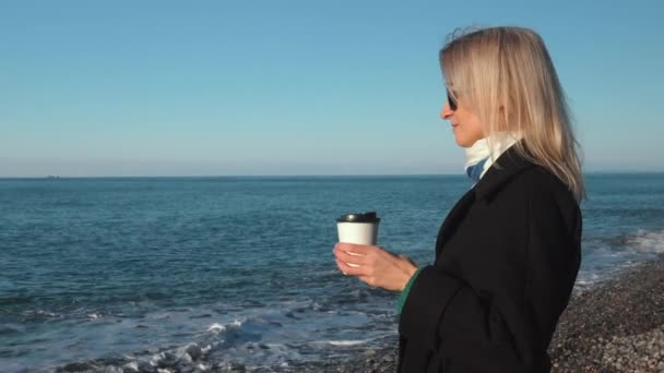 Blond Kvinna Svart Rock Och Solglasögon Njuter Kopp Kaffe Stranden — Stockvideo