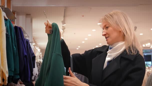 Модна Жінка Переглядає Полиці Модного Бутіка Пошуках Ідеального Вбрання Ретельно — стокове відео