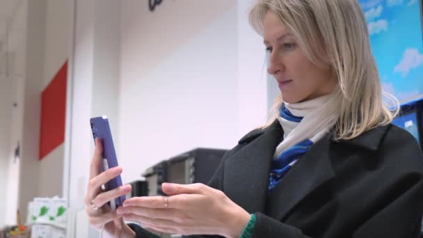 Ung Kvinna Väljer Smartphone Elektronikaffär Närbild Hon Plockar Upp Smartphone — Stockvideo