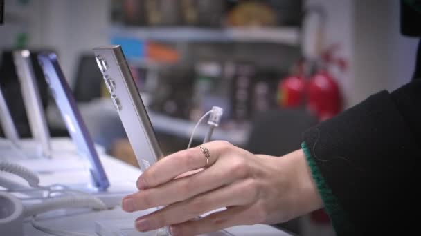 Jonge Onherkenbare Vrouw Kiest Smartphone Elektronicawinkel Close Pakt Smartphone Van — Stockvideo