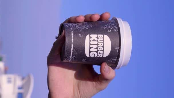ジョージア州バトゥミ 2024年 バーガーキングのテイクアウトから手札にコーヒーを入れた若い女性 キングコーヒーバーガー 紙コップ 輝かしい ビデオ — ストック動画