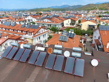 Bir kır evinin çatısındaki insansız hava aracının fotovoltaik güneş panellerine yakın çekim. Fethie, Türkiye. Fotovoltaik güneş panellerinin boyutunu küçültüyorum. Sıcak su kazanları güneş ışığıyla ısıtılır..