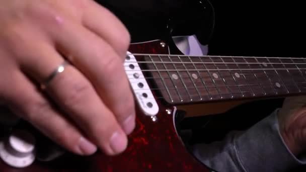 エレクトリックギターを演奏する男 情熱的なメロディーを巧みに作り出す男の手のクローズアップ 弦やフレーズで滑らかに動く指 — ストック動画