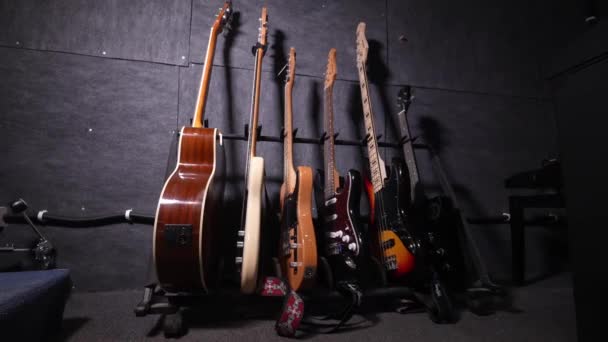 Akusztikus Basszusgitárok Sokszínű Színben Elegánsan Kiállítva Fali Akasztókon Vagy Polcon — Stock videók