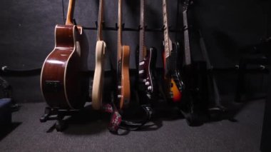 Çok renkli renklerde akustik ve bas gitarları duvardaki kancalarda ya da plak dükkanındaki raflarda, kayıt stüdyosunda ya da konserde zarif bir şekilde sergileniyordu. Hareket Kamerası.