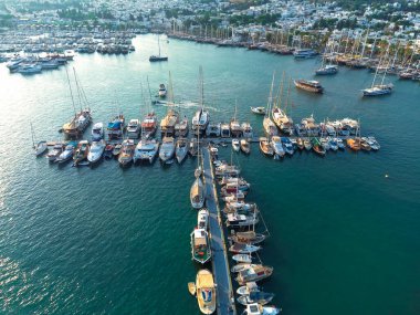 Türkiye 'nin Mugla kentindeki Bodrum limanının gün batımında muhteşem insansız hava aracı manzarası.