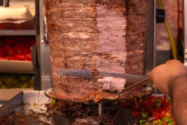 Geleneksel bir sokak yemeği bağışçısı kebabı ya da shawarma için et kesen bir şefin yakın çekimi. Sokak yemeği kavramı