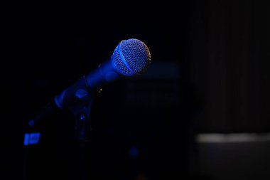 Close-up of a microphone with blue backlight in a music studio, at a concert in the dark, copy space clipart