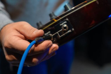 Konser salonunda gitarın fişini takan adamı kapat. Kayıt stüdyosundaki tanınmayan kişi enstrümanı bağlıyor. Bilinmeyen ses mühendisi elektro gitarı çalmaya hazırlıyor.