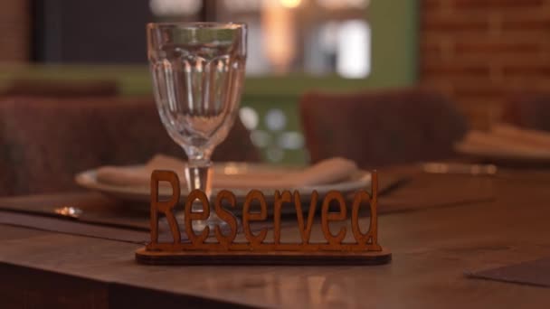 Şık Ahşap Rezervasyon Levhası Cam Arka Planda Gurme Restoranındaki Masaya — Stok video