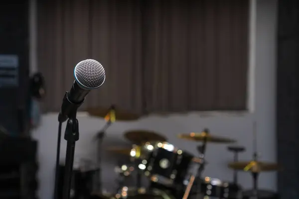 Nahaufnahme Des Mikrofons Vor Dem Hintergrund Eines Unscharfen Schlagzeugs Studio Stockfoto