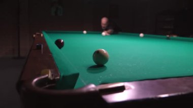 Rus bilardosu oynuyorum. Arka plandaki adam topa vuruyor, beyaz topu cebine atıyor ve ıskalıyor. Rus bilardo masası, top. Başarı Değil kavramı. Top delikte değil. Dava.