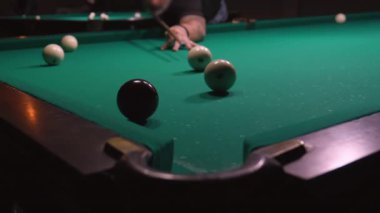 Rus bilardosu oynuyorum. Arka plandaki adam topa vuruyor, beyaz topu cebine atıyor. Rus bilardo masası yeşil, top cebe uçuyor. Başarı kavramı. Top delikte. Dava.