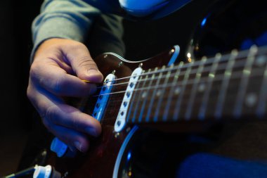 Elektro gitar çalarak elinizi kapatın. Gitar çalan müzisyen, canlı müzik. Gitar çalan adam. Müzik aleti. Elektro gitar. Rock müzik grubunun tekrarı.