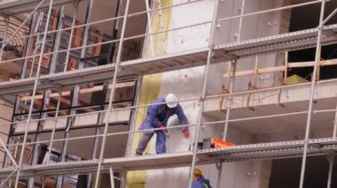 İşçiler bina cephesinden duvarlar örüyorlar, inşaat altındaki duvarlar inşaat konsepti inşaatı ve inşaat alanında çizim yapan mimarlar.