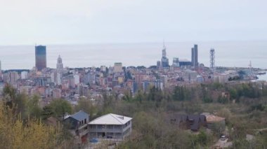Güneşli bir günde Batumi 'nin kuş bakışı görüntüsü. Gürcistan 'a seyahat - yeşil ağaçlar ve Sameba tepesinden deniz manzaralı banliyöleri olan Batumi şehri manzarası.