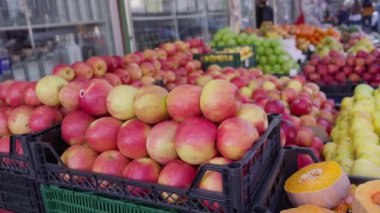 Elmalar ve diğer meyveler Batumi kentindeki sokak pazarında farklı renklerde raflara dizilmişti. Sokak ticareti. Çanta. Meyve vitrininde taze elmaların yakın çekimi.