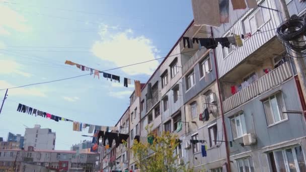 Reine Bunte Klamotten Hängen Seilen Zwischen Gebäuden Auf Blauem Himmelshintergrund — Stockvideo