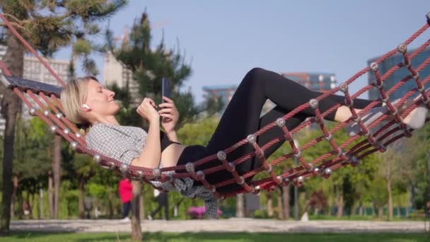 Mulher Loira Jovem Caucasiana Usando Smartphone Ouvindo Música Fones Ouvido — Vídeo de Stock