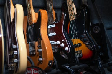 Bir müzik stüdyosunda ya da bir mağazada, duvarın yanında duran güzel gitarların yakın çekimi, seçici odaklanma..