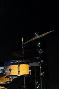 Stüdyodaki bir ağacın rengiyle eşleşen bir davul setinin yakın plan görüntüsü. Dikey fotoğraf