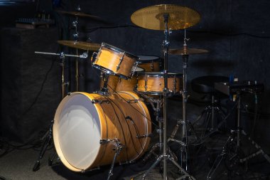 Stüdyodaki bir ağacın rengiyle eşleşen bir davul setinin yakın plan görüntüsü.