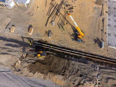 Deniz kıyısında inşaat çalışmaları var. Ağır makineler, temeli su ve fırtına dalgalarından güçlendirmek için çalışıyor. İnsansız hava aracından görüntüle.