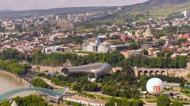 Gürcistan, Tiflis 'in merkezinden bak. Rike Park, Kura River, fütüristik bir sergi salonu ve bir müzik konseri. Barış Köprüsü. Hava balonu. Eski şehrin güzel manzarası