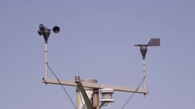 Rüzgarın yön ve yön yönünü göstermek için mavi gökyüzüne değen rüzgar gülü ve kuzeydoğu yönüne doğru esiyor. Demir rüzgar gülünün komik silueti. Rüzgâr gülü başlıca yönlerdedir.