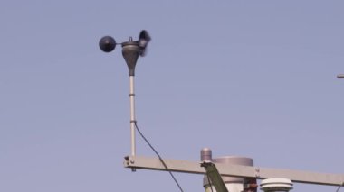 Rüzgarın yön ve yön yönünü göstermek için mavi gökyüzüne değen rüzgar gülü ve kuzeydoğu yönüne doğru esiyor. Demir rüzgar gülünün komik silueti. Rüzgâr gülü başlıca yönlerdedir.