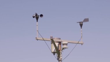 Rüzgarın yön ve yön yönünü göstermek için mavi gökyüzüne değen rüzgar gülü ve kuzeydoğu yönüne doğru esiyor. Demir rüzgar gülünün komik silueti. Rüzgâr gülü başlıca yönlerdedir.