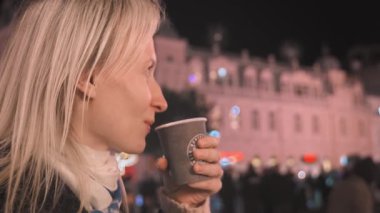 Kafkasyalı zarif bir kadın geceleri geleneksel Noel festivalini kutluyor. Süslü fuar alanının tadını çıkarırken sıcak şarap içen genç bir kız. Yeni yıl arifesi ve Noel kutlaması