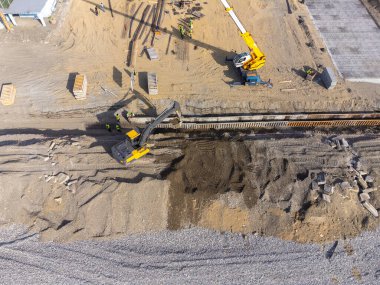 Deniz kıyısında inşaat çalışmaları var. Ağır makineler, temeli su ve fırtına dalgalarından güçlendirmek için çalışıyor. İnsansız hava aracından görüntüle.
