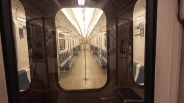 Boş metro vagonunun yan ve merkez koridorlarında sıra sıra mavi koltukları var. Bu da şehir ulaşımında sakin bir atmosfer yaratıyor.