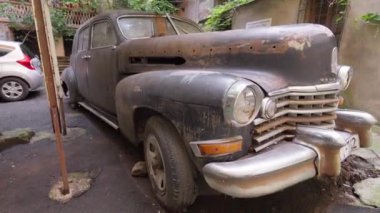 Tiflis, Georgia 2 Mayıs 2024: Terk edilmiş siyah vintage Cadillac arabası, Gürcistan 'ın Tiflis kentindeki avluda dinleniyor..