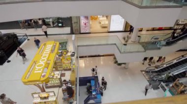 Tiflis, Yunanistan - 2 Mayıs 2024: Çok katlı alışveriş merkezlerinden geçen müşteri ve çalışanlara yukarıdan bir bakış. Yürüyen merdivenler ve perakende mağazaları görülebilir.